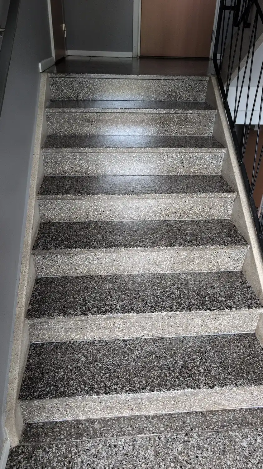 Nystädad trapphustrappa i terrazzo i en fastighet.